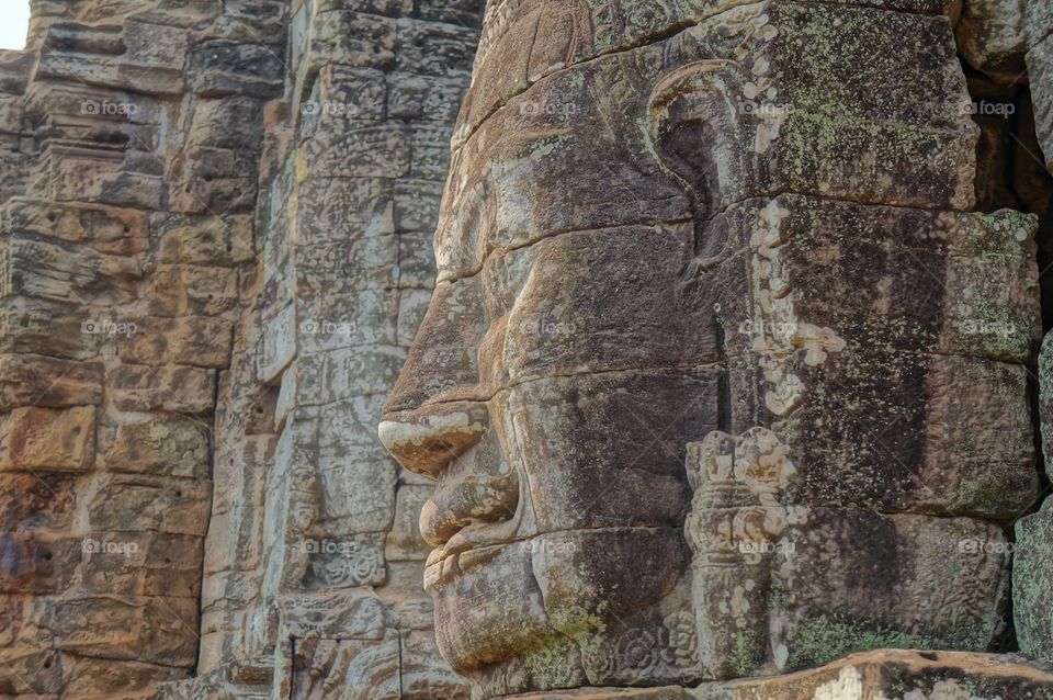 Buddha . Buddhas face carved in stone at complex of temples in Anglor Wat in Cambodia