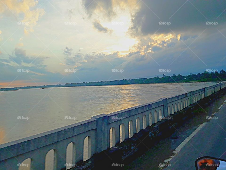 Subansiri river on the bridge with sunset cloud sky. Reflection of sunset.