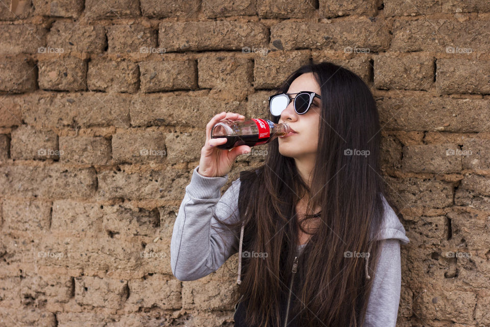 Young woman drinking Coca-Cola