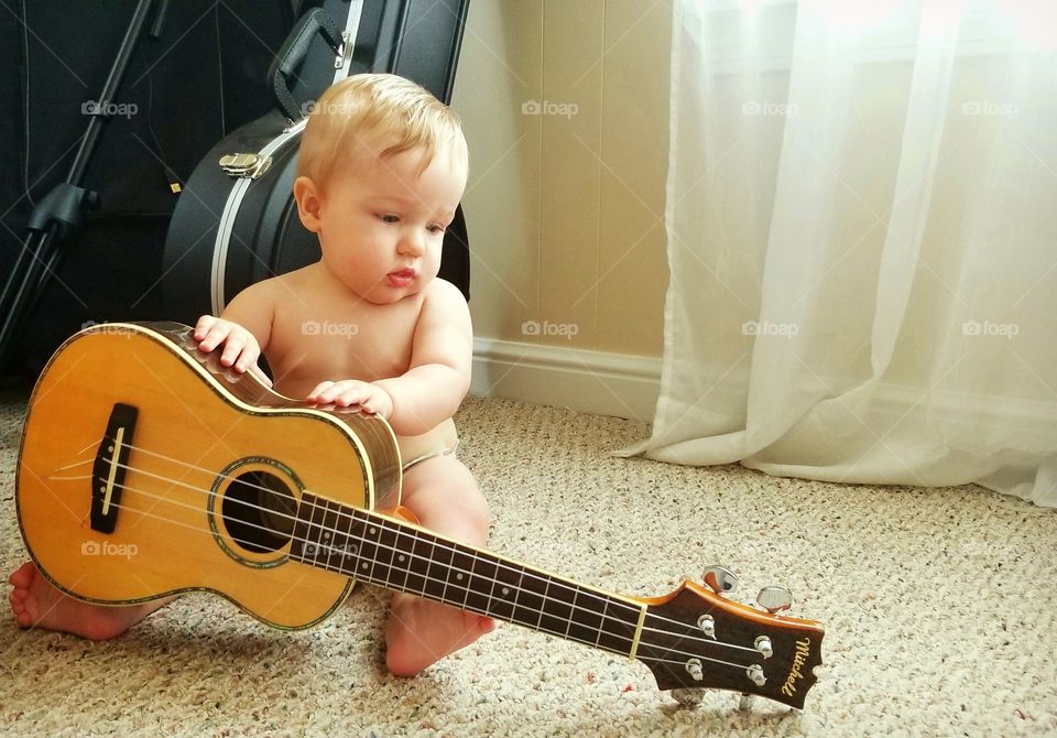 Baby boy playing ukulele