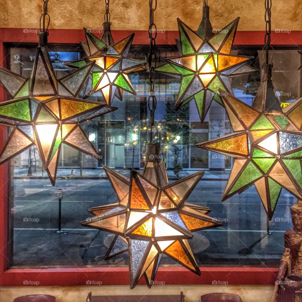 Warm lamps, cool street. A view from inside a room with warm light looking thru a window into the night