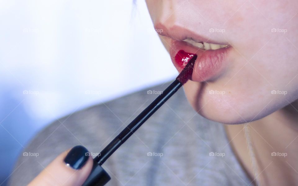 woman paints her lips with lipstick