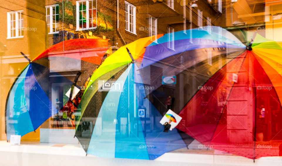 playing with light and reflection to get a photo of the umbrellas and the city streets outside the shops