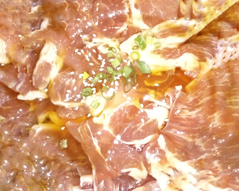 Sliced pork marinated with sauce and white sesame seeds