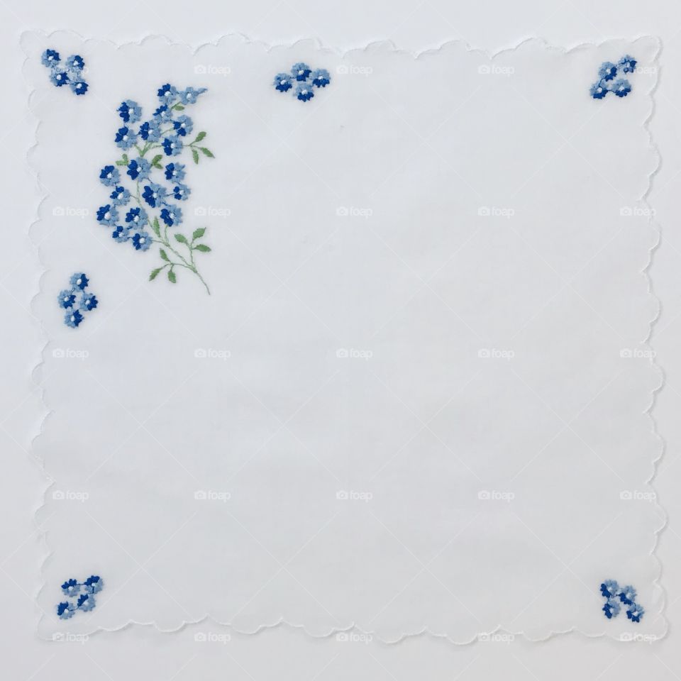Beautiful two tone blue little flowers hand embroidery embroidered floral design with blank plain solid white empty background 