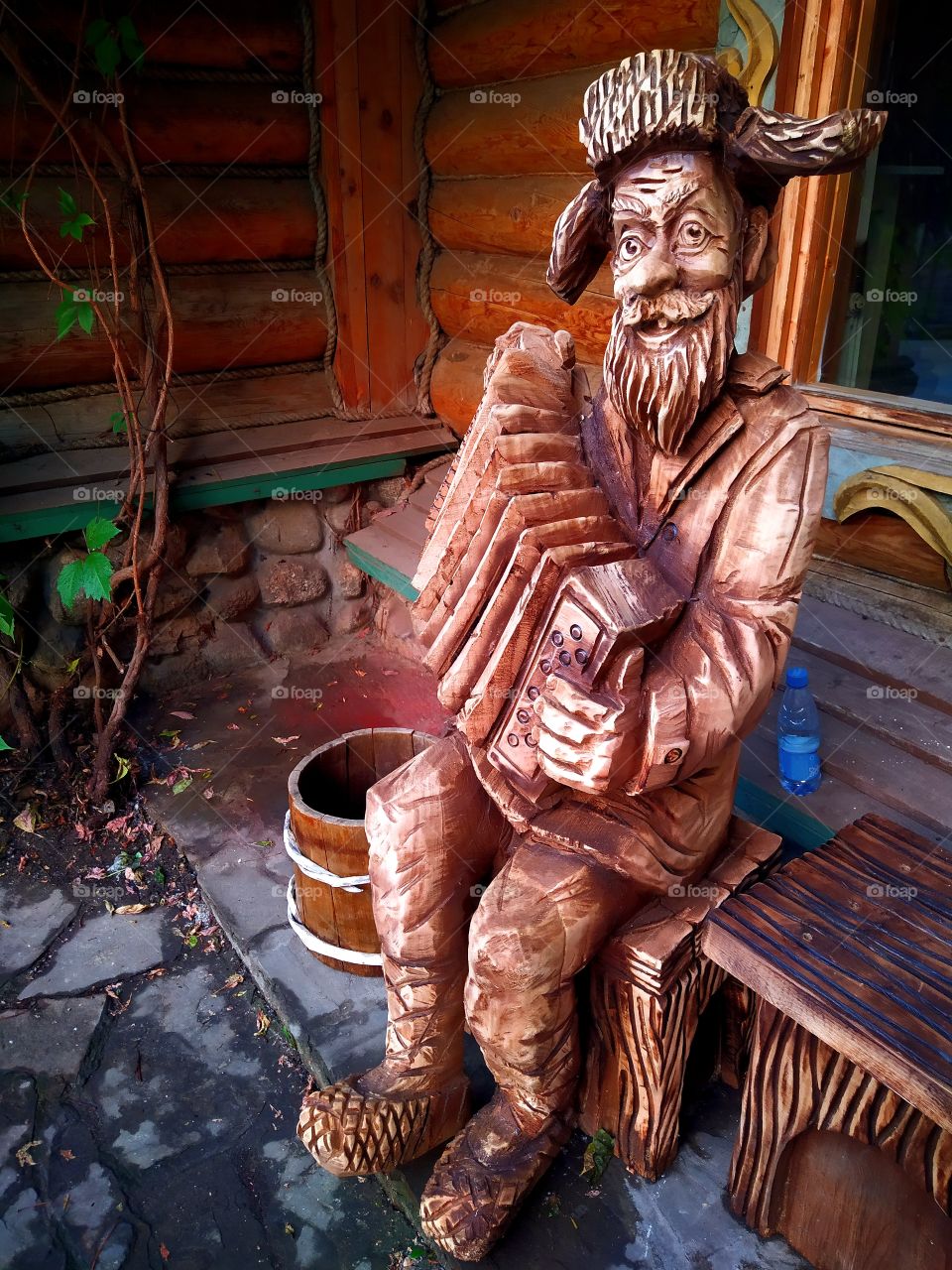 Wooden figure of a cheerful grandfather who plays the accordion