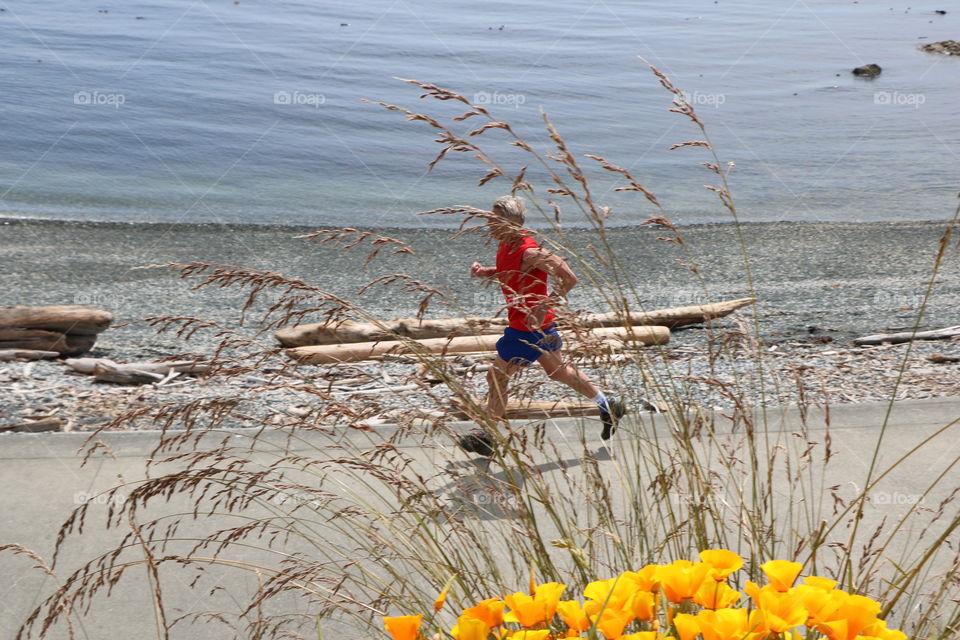 Middle aged man running by the ocean 