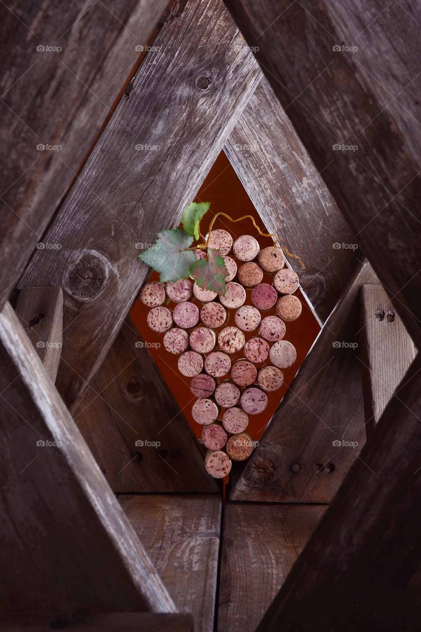 Wine corks simulating a bunch of wine grapes in a rustic wood setting.