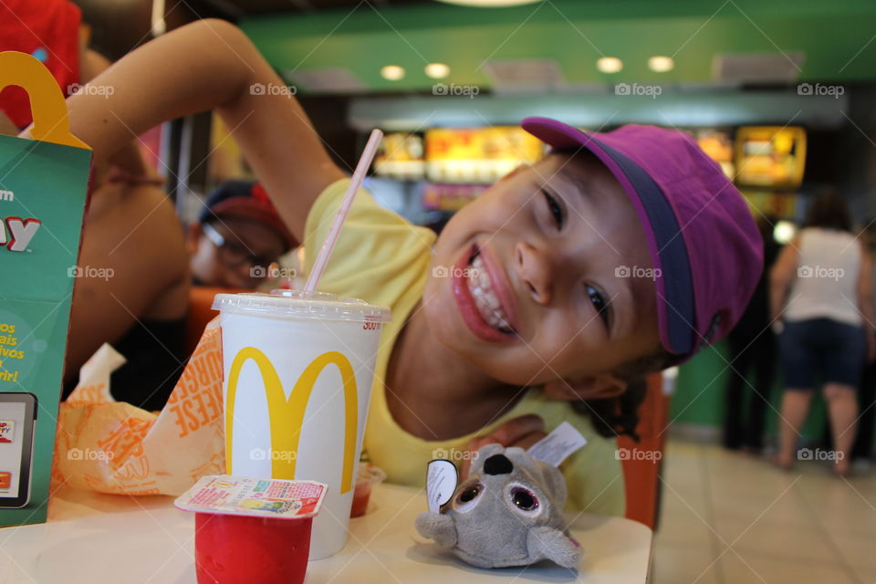 little happy girl eating at McDonald's