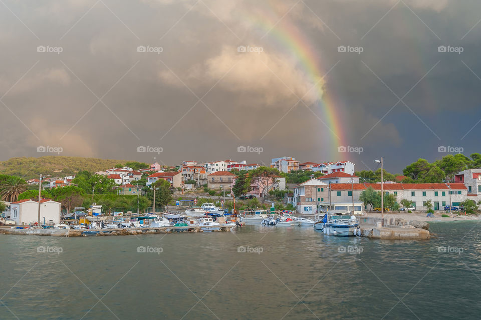 Rainbow in harbor of small fishing village in Croatia.