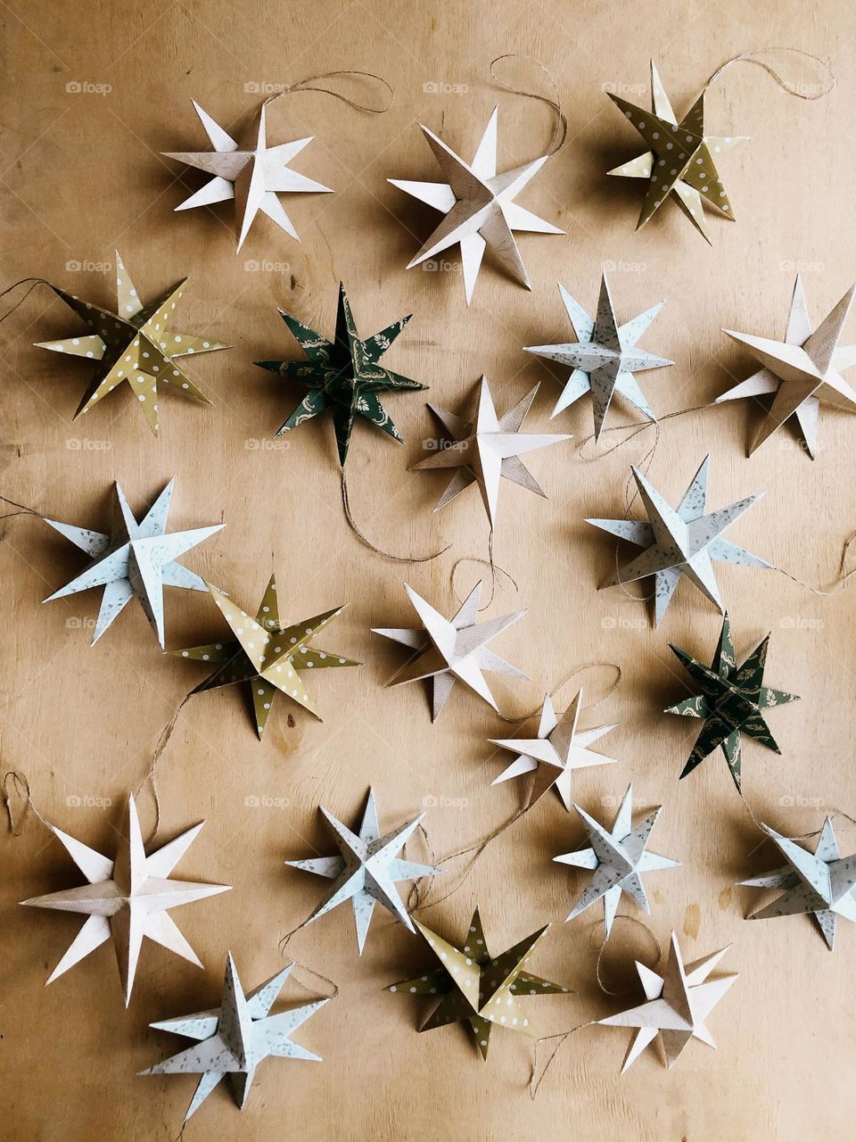 A set of paper Christmas stars on a wooden table, no people, triangle 