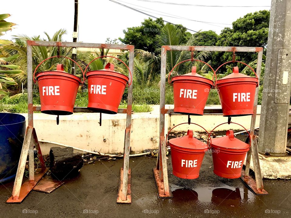 Red buckets with water at the gas station. To be used in case of fire. Mauritius island, Africa.