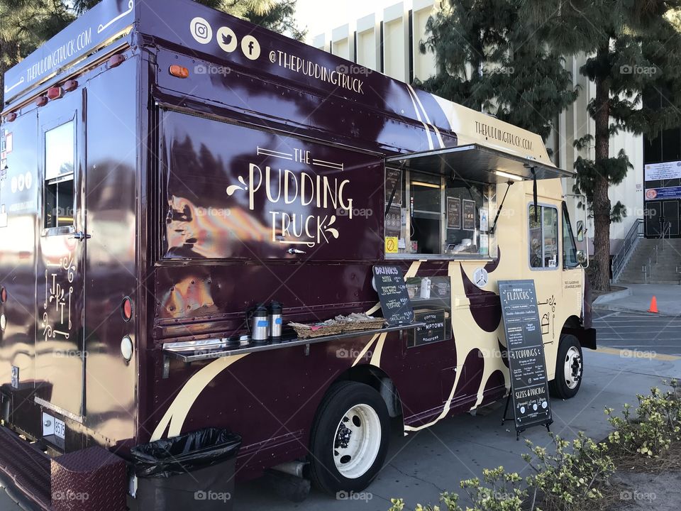 A food truck parked outside a building selling pudding