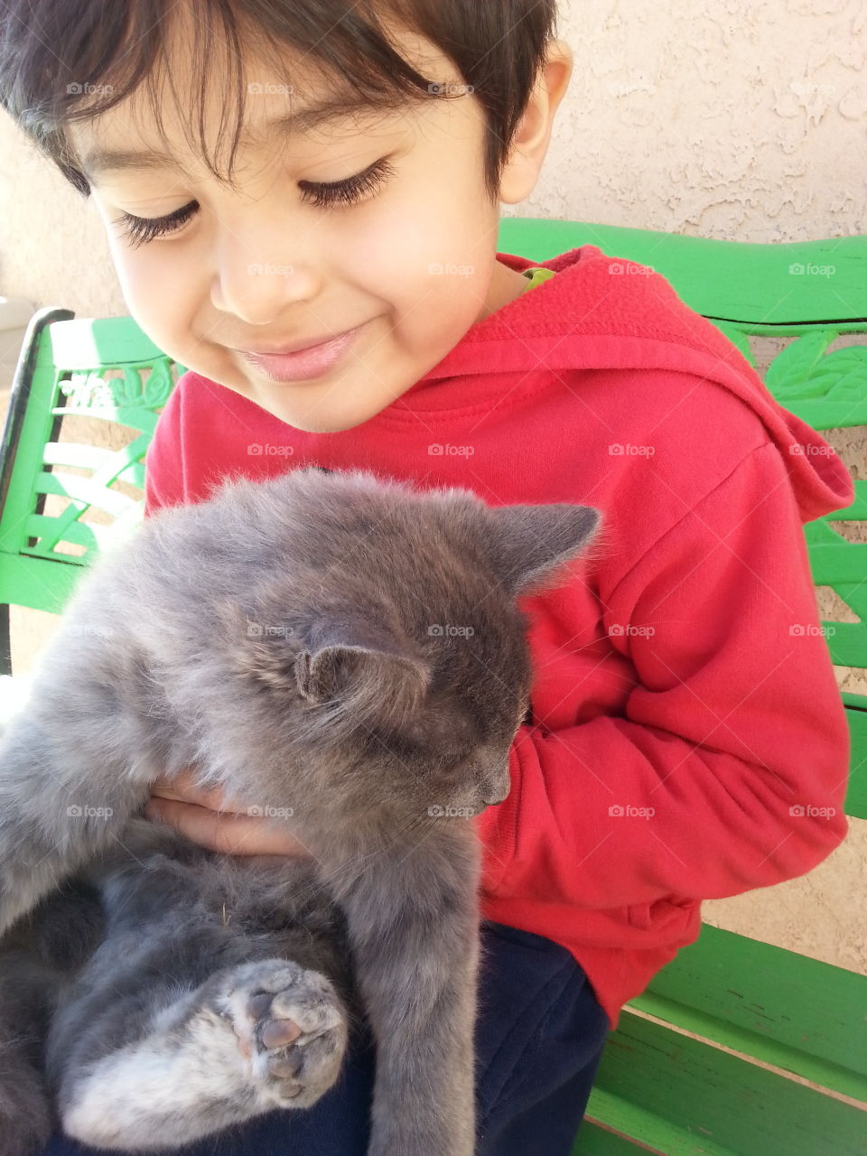 holding a kitty. boy holding a fluffy cat