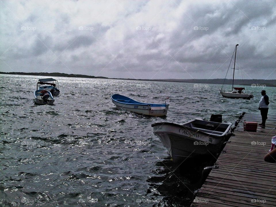 beautiful beach landscape, and its boats anchored in the sea at sunset