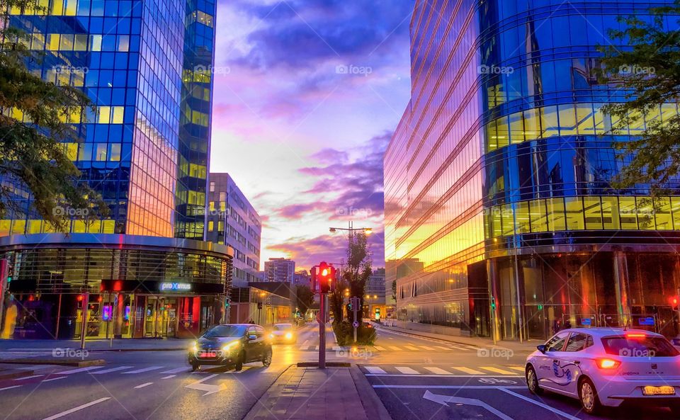 Colorful morning sky over the city streets, reflected in the glass windows of the office buildings of the business district of Brussels 