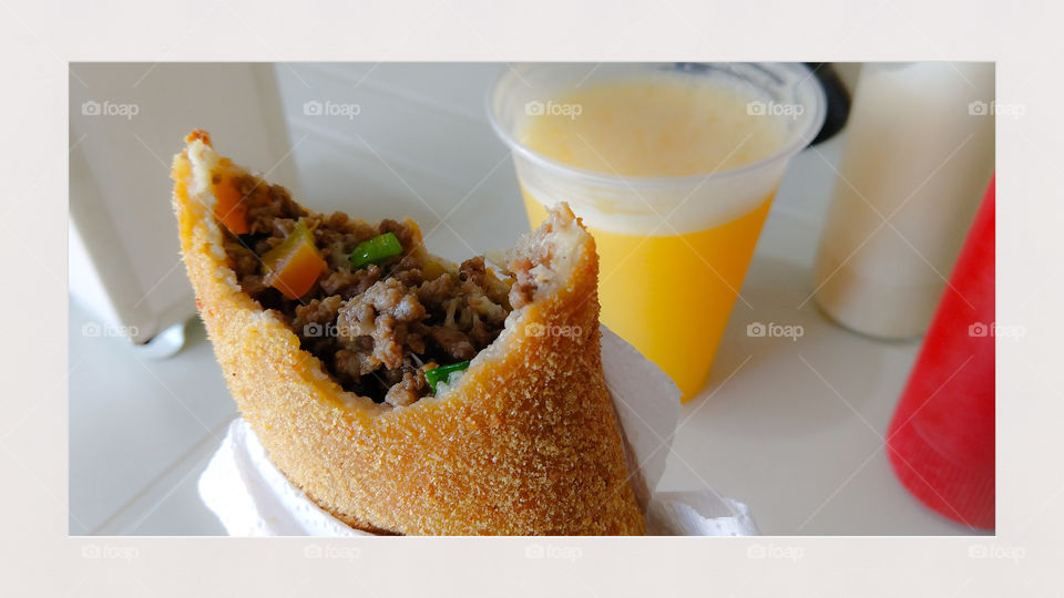 Risole, salgado com suco de laranja.