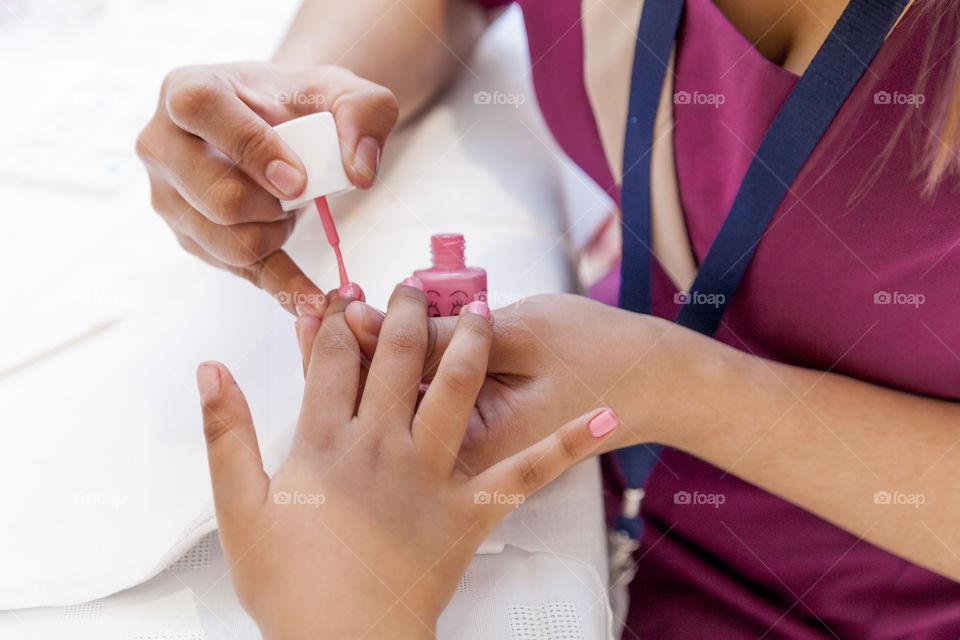 Master doing pink manicure, hands in frame