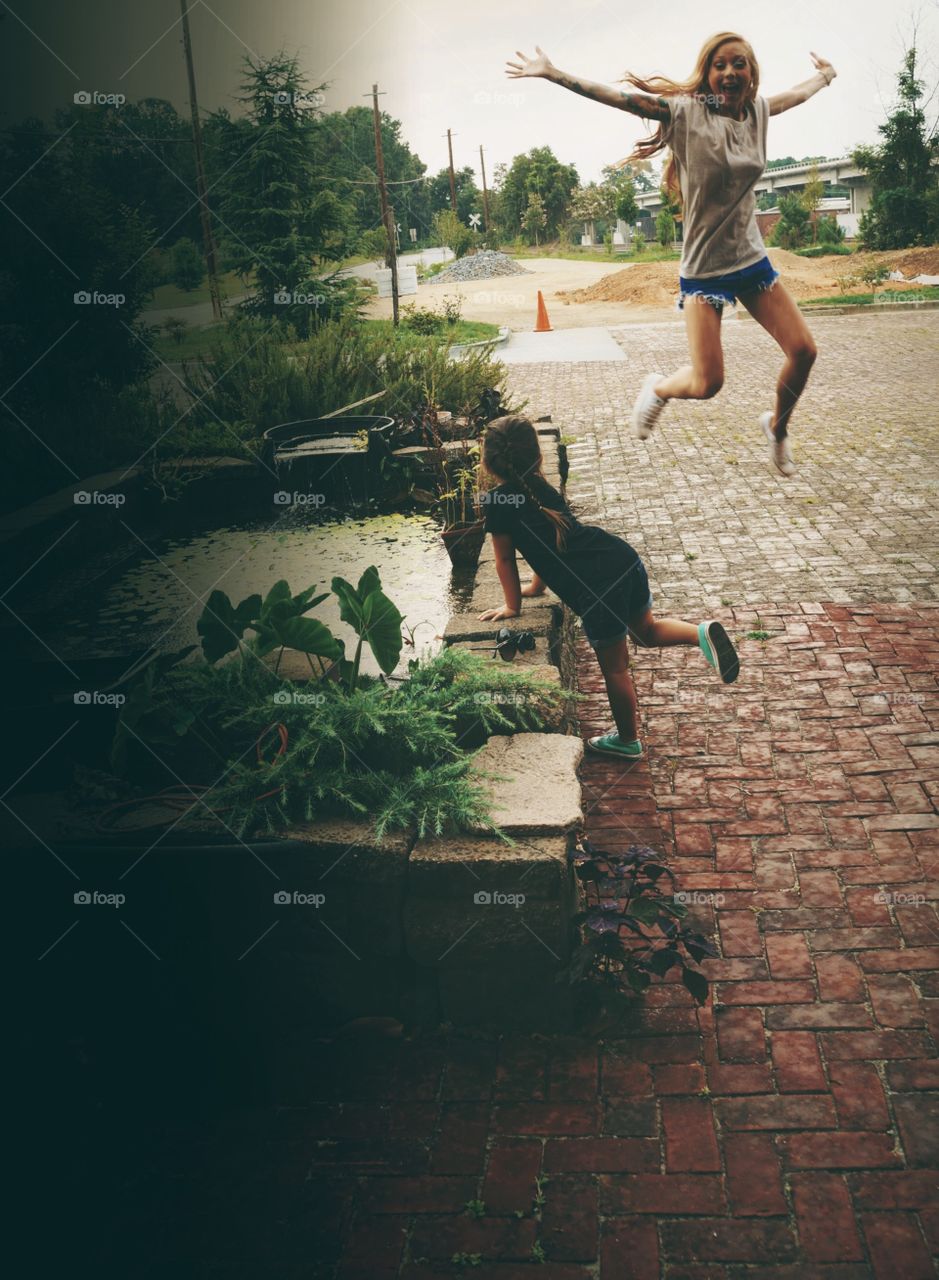 Girl jumping on cobblestone in the village