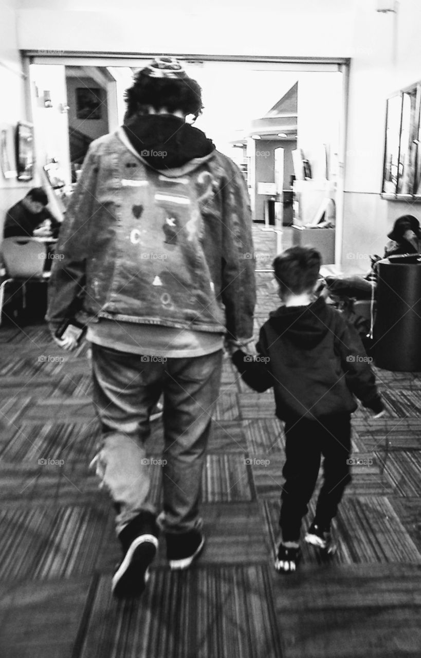 Sweet picture of a big brother walking hand in hand with his little brother.