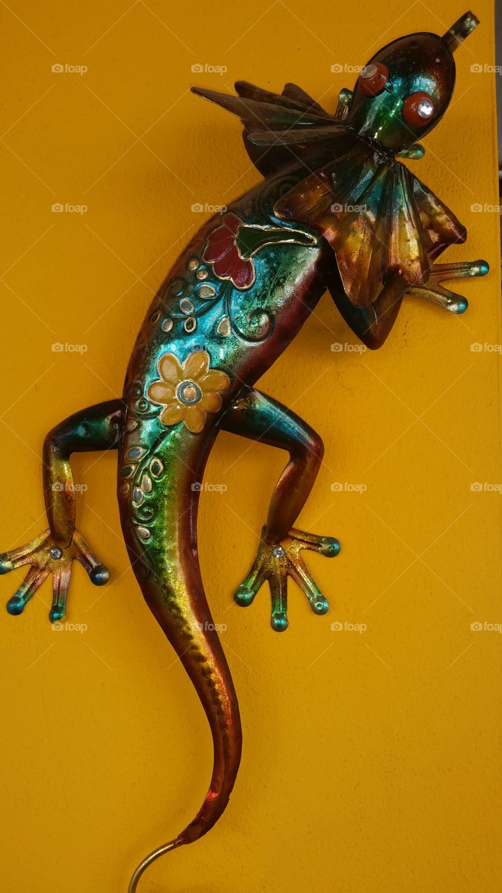 Colorful metal lizard on wall