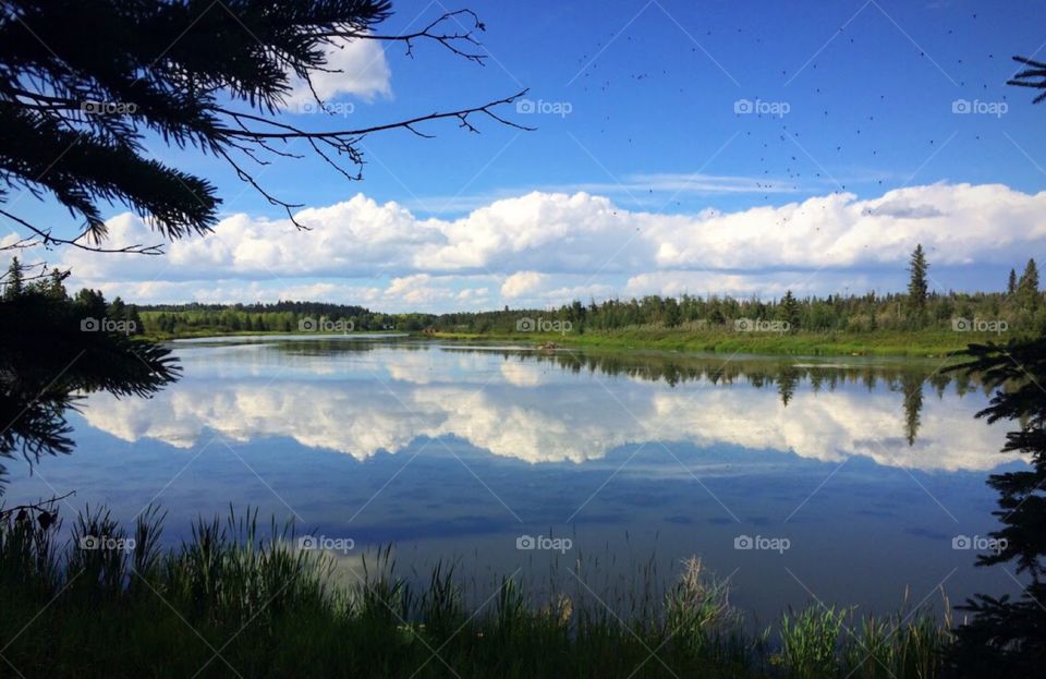 Clouds perfectly reflecting on the water creating a beautiful mirrored image 