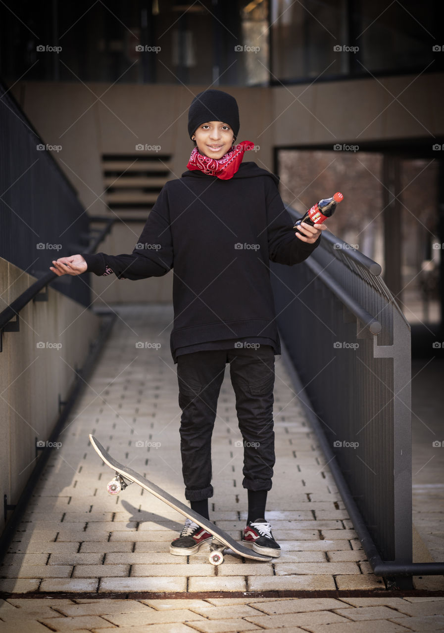 Teenager with skateboard and coca-Cola in the city