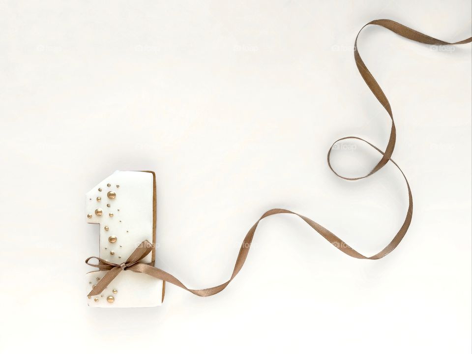 gingerbread in the shape of the figure 1, number one with golden decor, shiny holiday tape