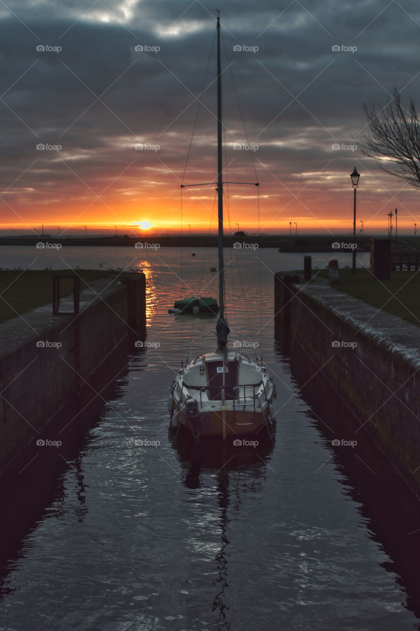 Beautiful sunrise at Claddagh, Galway, Ireland with hidden sailboat