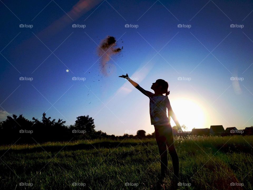 Female silhouette on sunset background