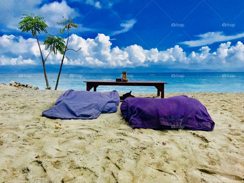 Two chairs And a table on a sandy beach