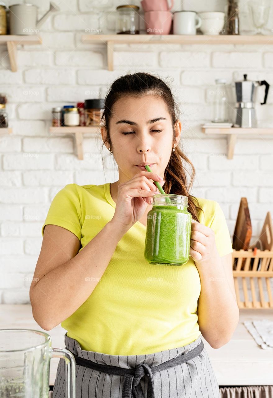 woman drinking green smoothie