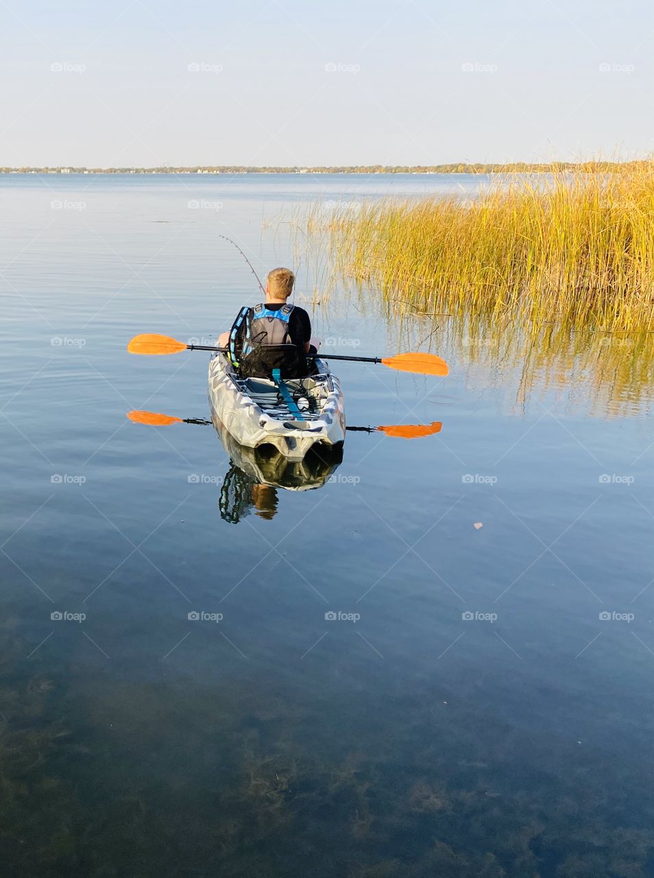 Gorgeous photo of boy in his kayak very socially distanced from others. 