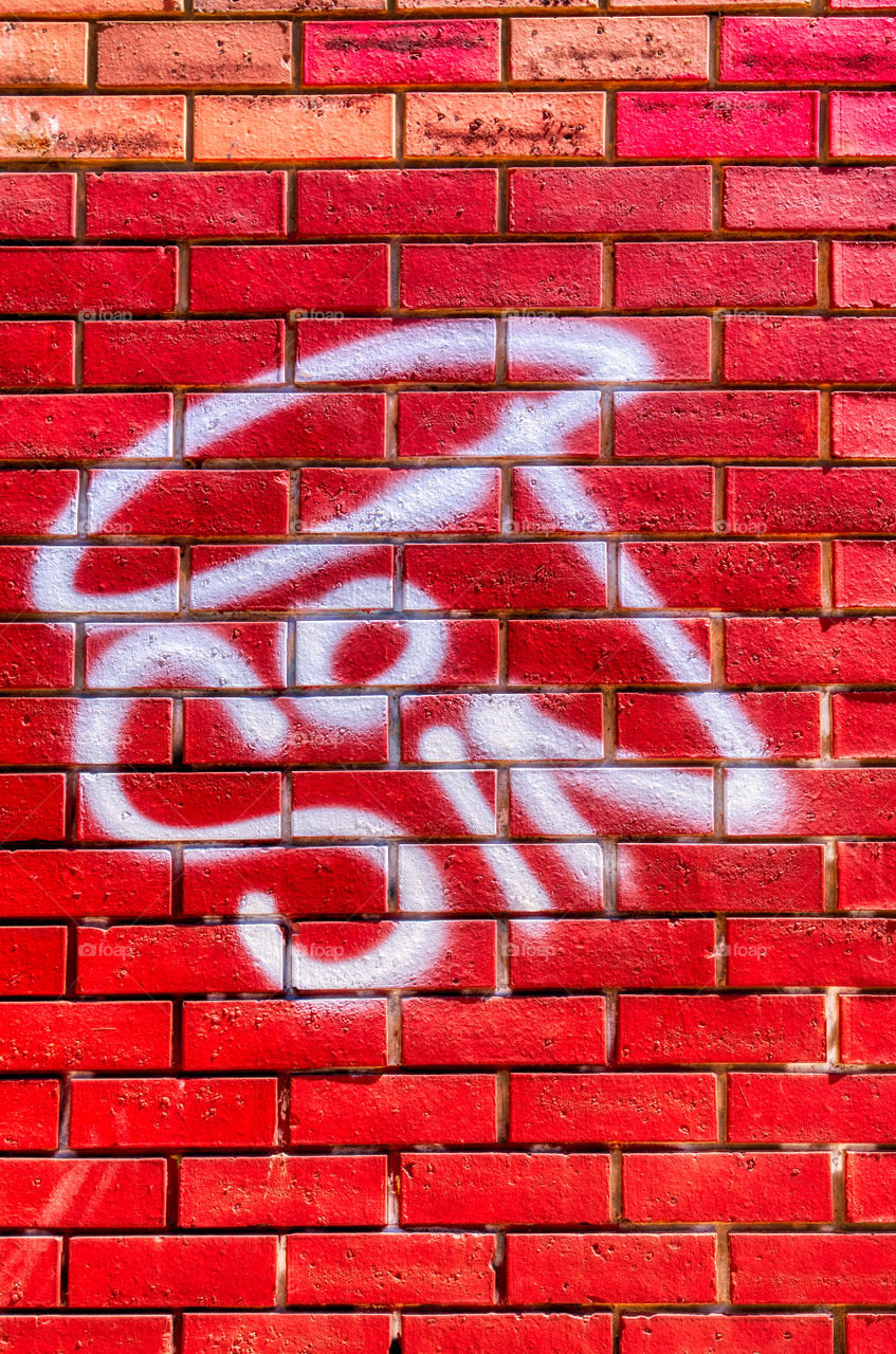 graffiti of the word Sin on a red brick wall