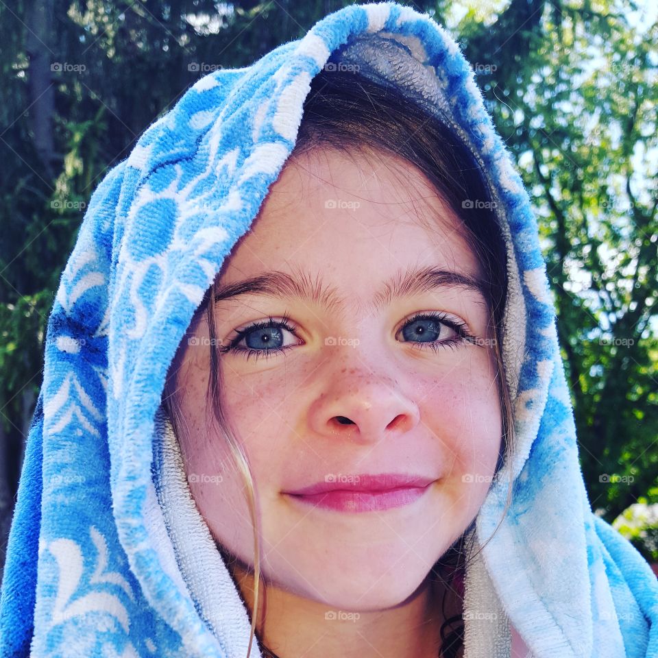 Girl with towel on head against tree