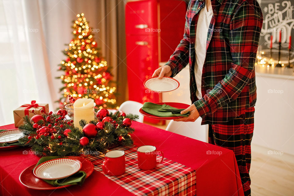 man sets a beautiful decorated winter table for a festive dinner.  Merry Christmas and Happy New Year.