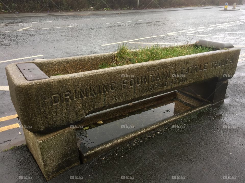 Stone drinking trough on a busy road , northern City.