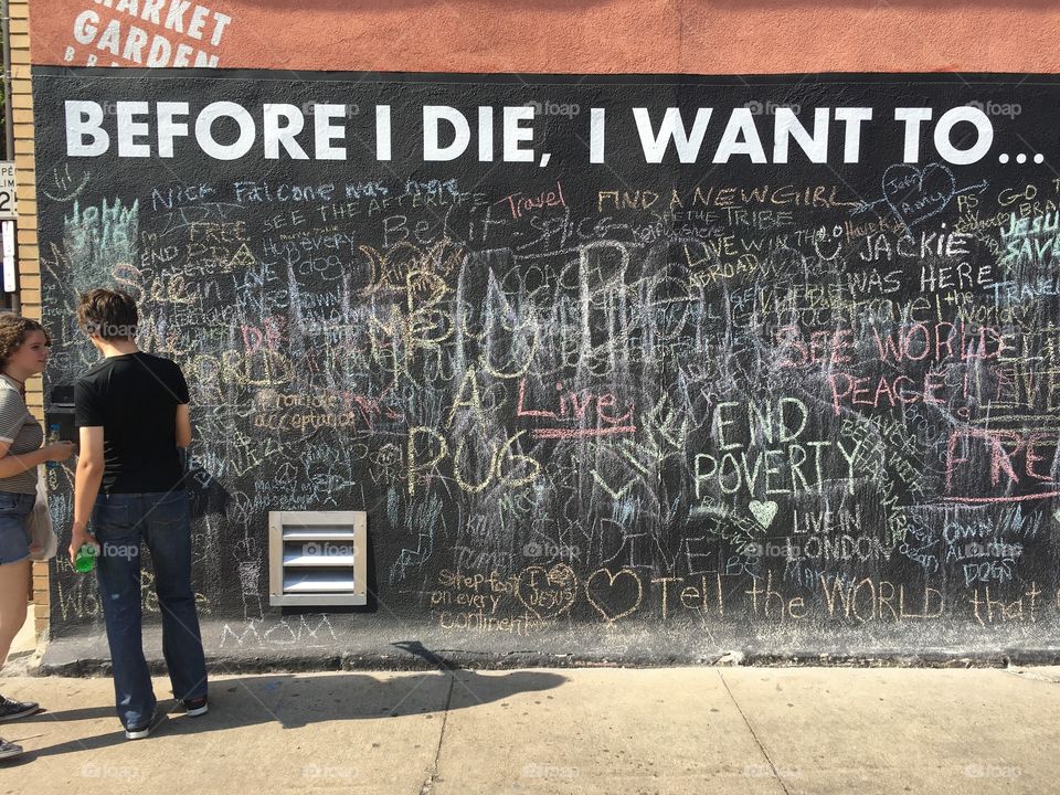 Man and woman standing near graffiti wall