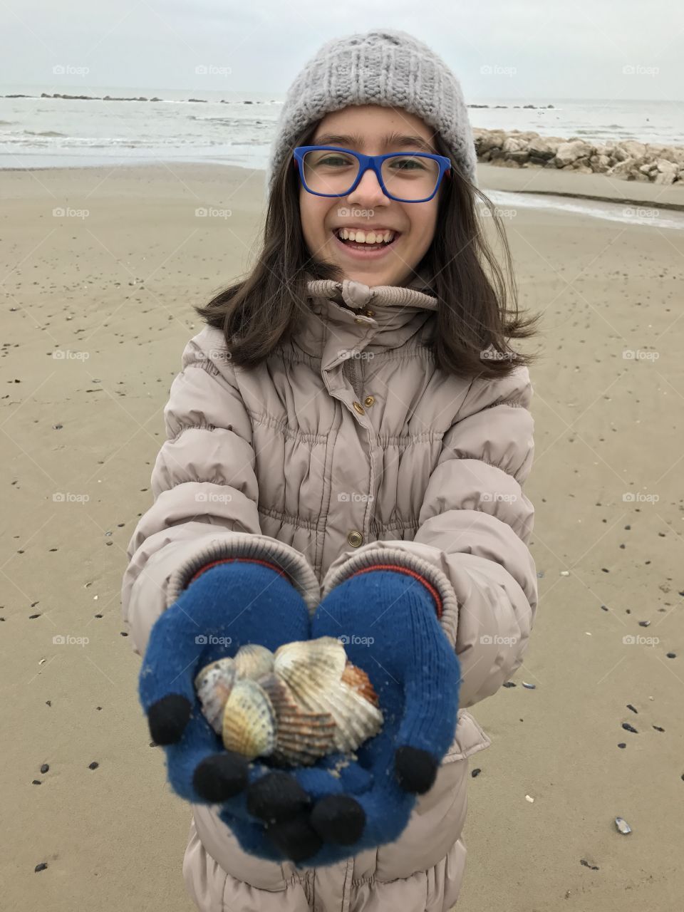 Girl holding shells in hand at beach