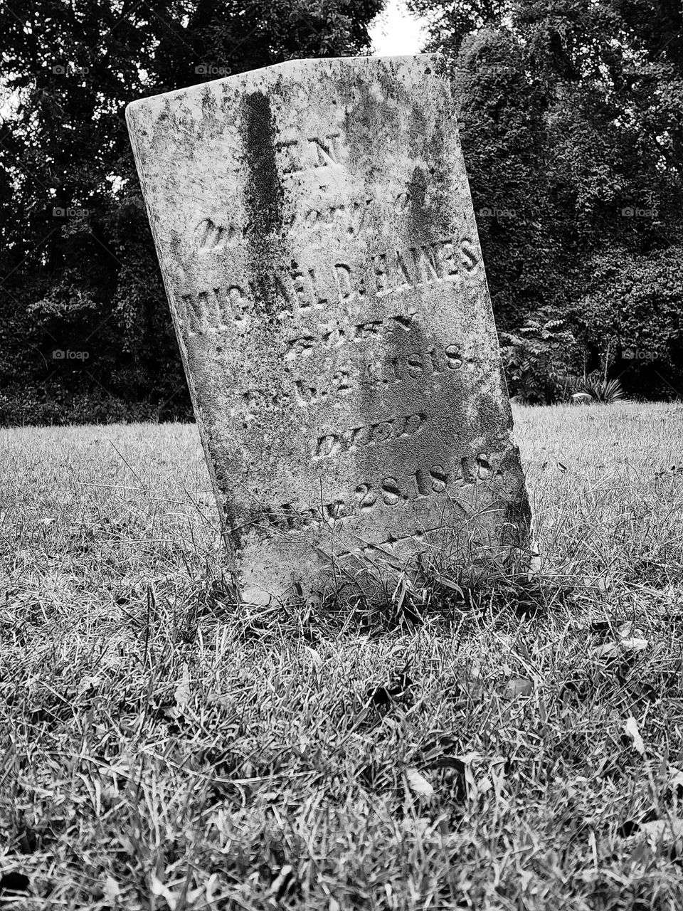 An old headstone leans after over a century in the ground reminding those who visit about a past life