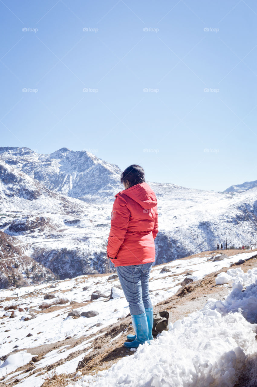 Hiker woman in red dress turn back standing after hiking to the top of a Himalayan mountain range of Everest region. Achievement, Freedom, Success concept. Copy room space text for January Calender.