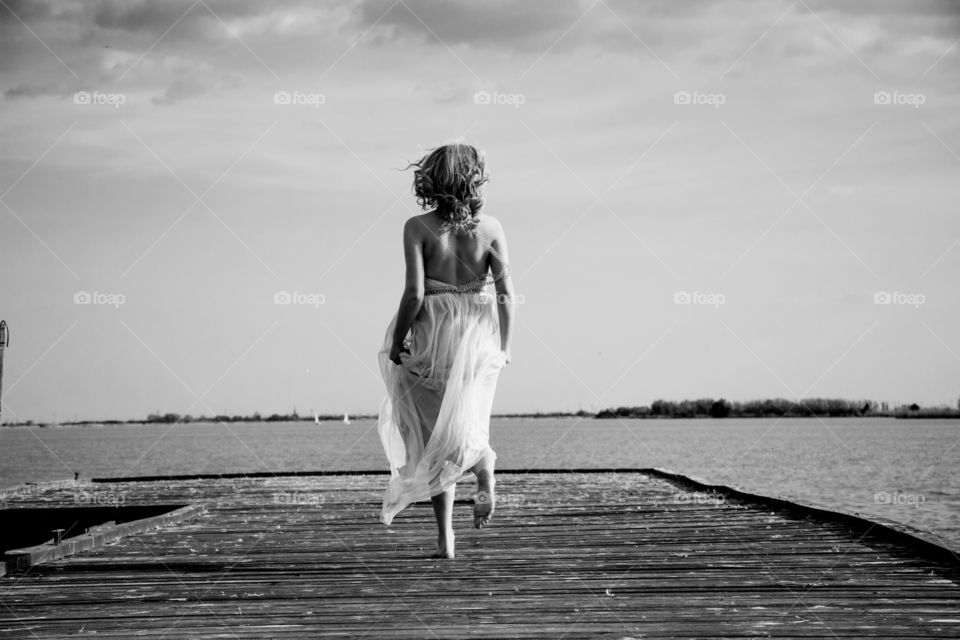 woman running on the deck. woman in beautiful evening gown running on the deck,monochrome photo