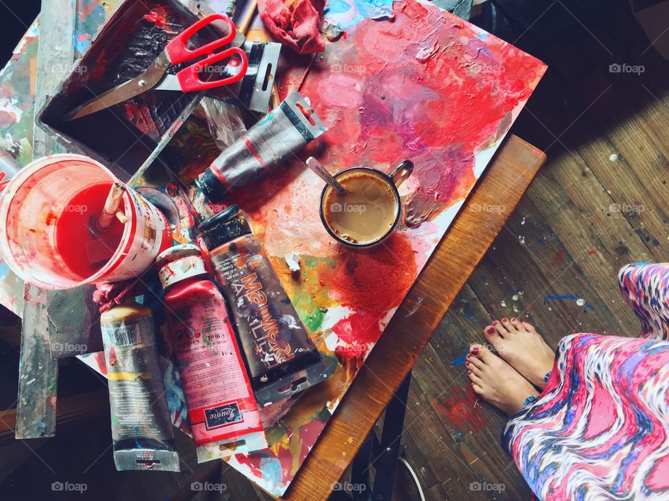 Feet view at favorite rituals: cup of morning coffee at my painting art table, full of colors. Both are inspiring and giving a good at art of the day. 