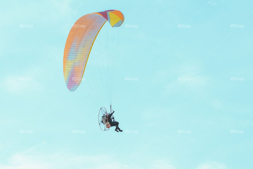 Paraglider flying in the blue sky