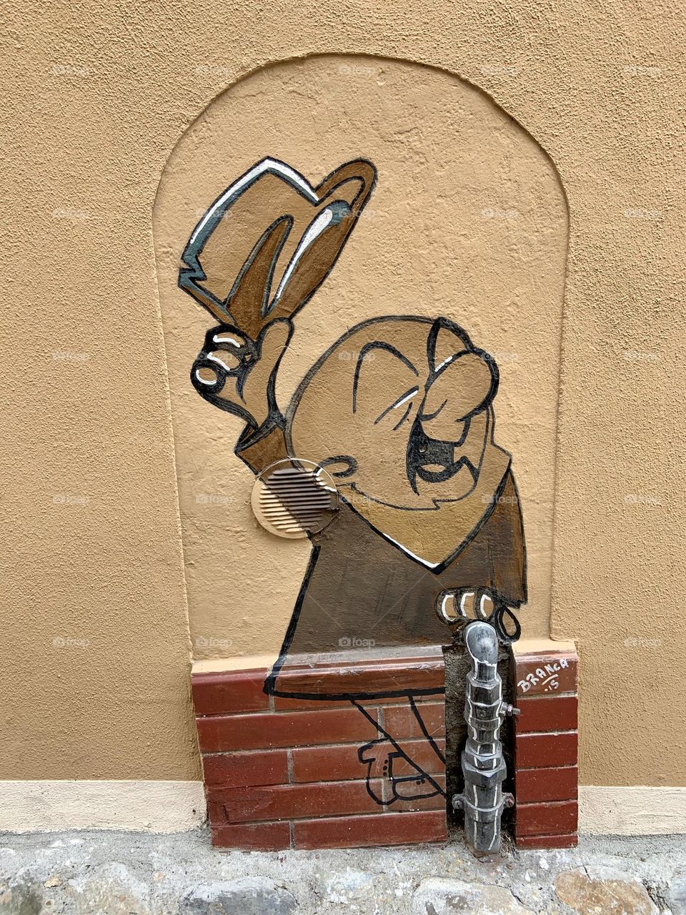 Man with hat over wall