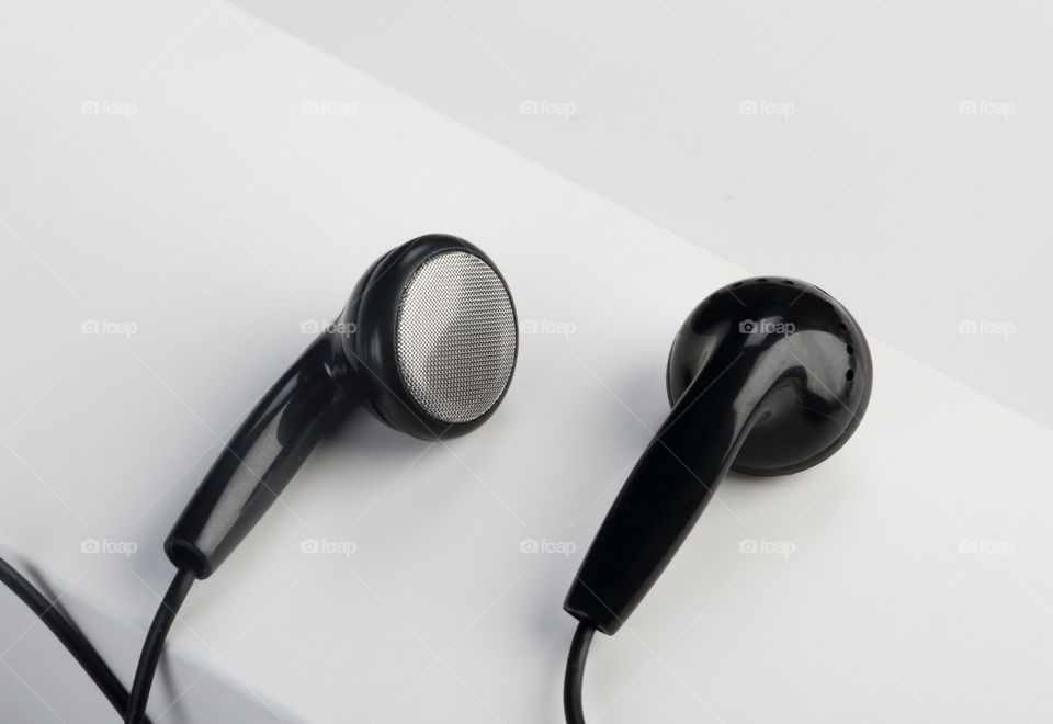 Black colored earphones on white background