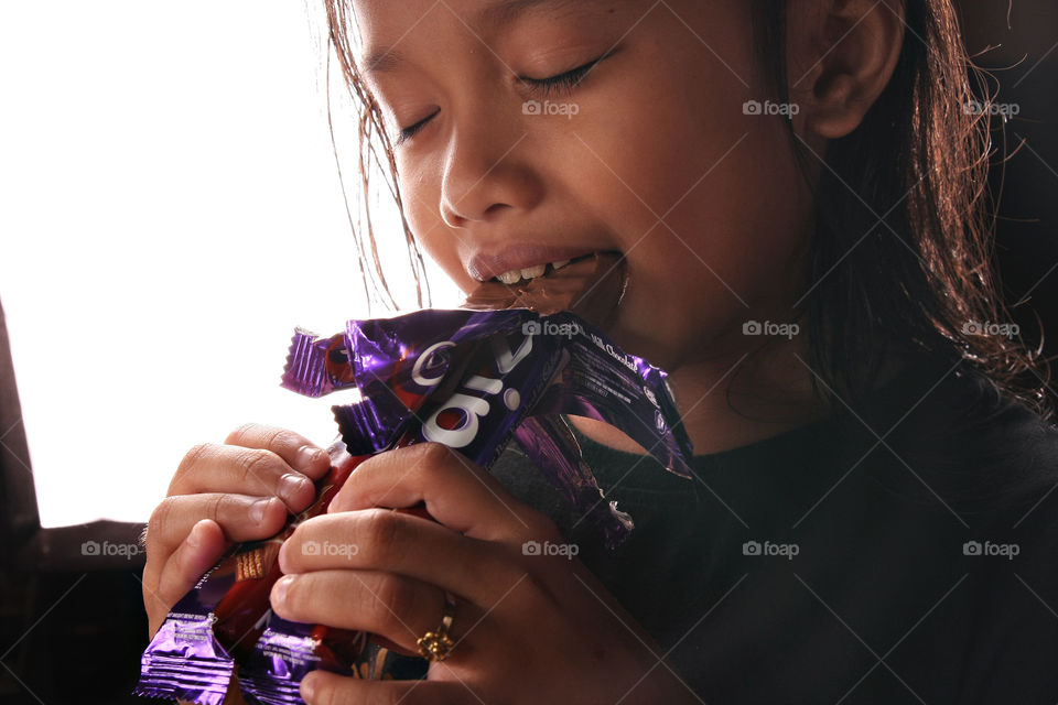 sweet tooth. a child eating s chocolate