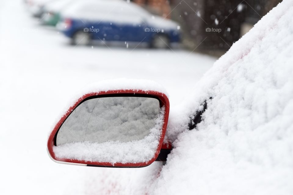 Rear car mirror with snow during winter. Slovakia