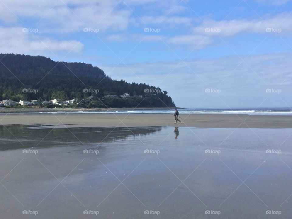 A Fisherman Walking Along the Beach
