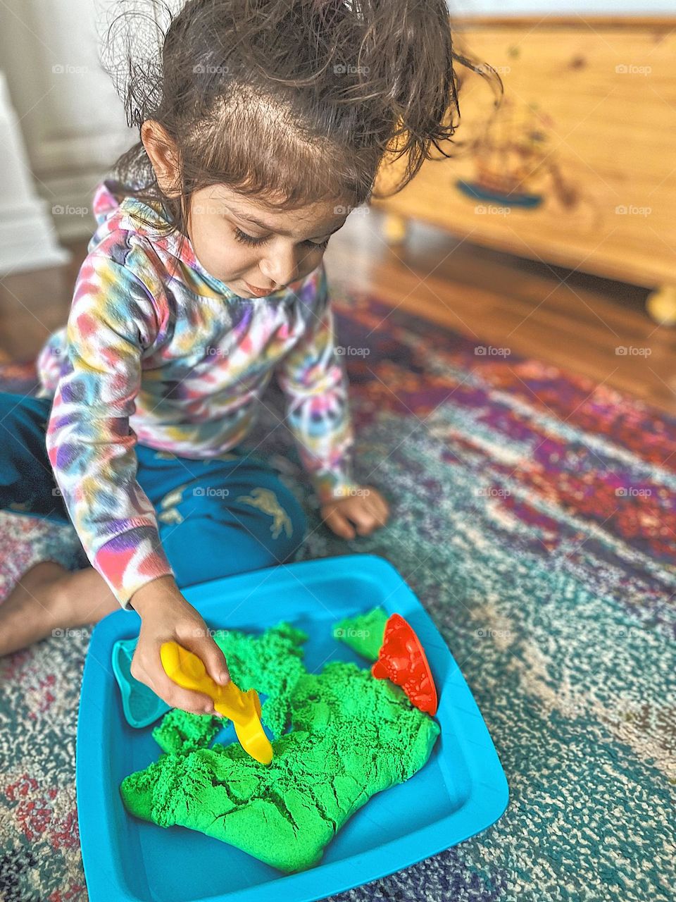 Toddler girl creates shapes out of Kinetic Sand, little girl playing with Kinetic Sand, shoveling and building with sand indoors, using Kinetic Sand indoors, Kinetic Sand creations, toddler girl plays with sand indoors, wintertime fun indoors 